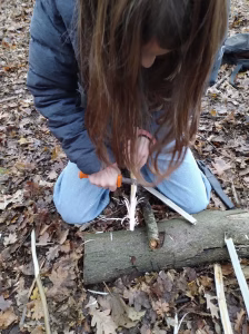 Werken met een mes is een van de outdoor vaardigheden die kinderen leren tijdens een workshop.